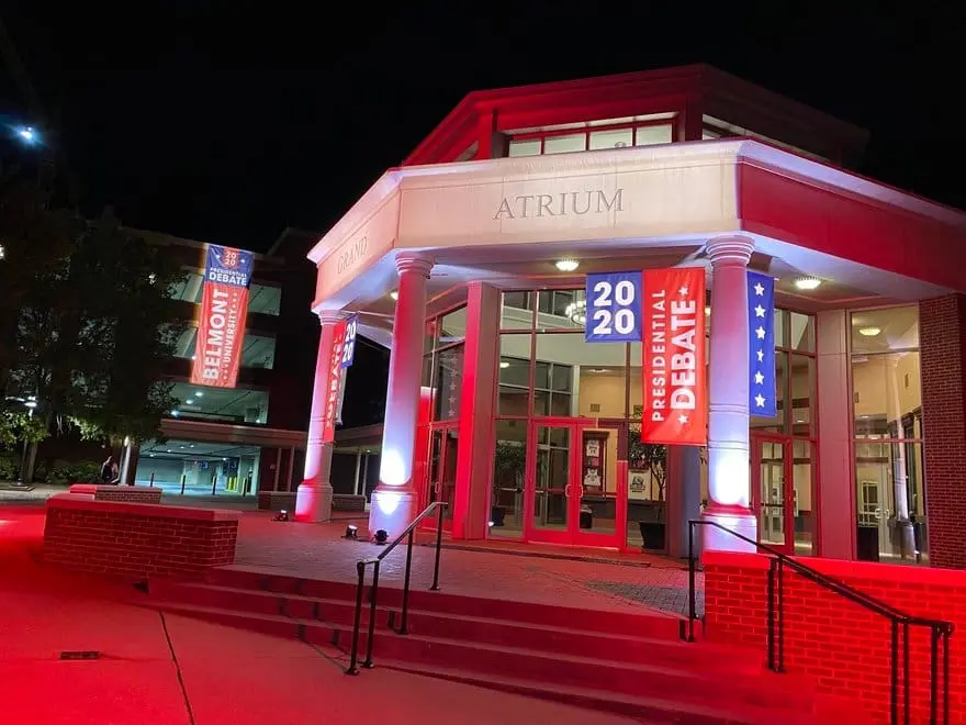 A performer sings passionately on stage with dramatic lighting.