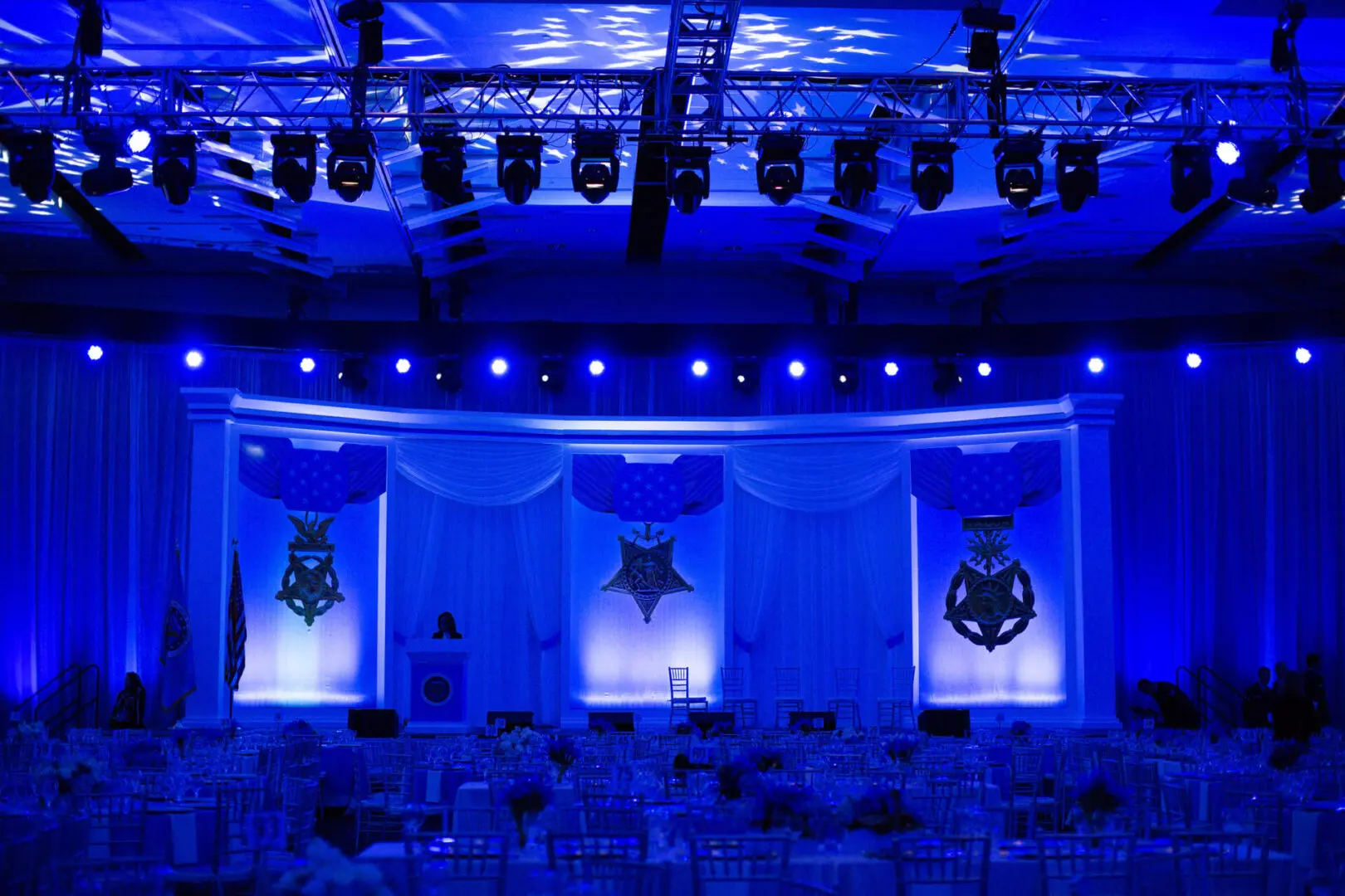 Stage setup with dramatic blue lighting and theatrical masks.