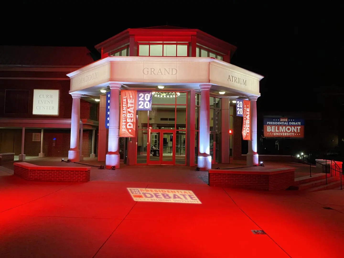 Entrance of a building illuminated in red light during nighttime.