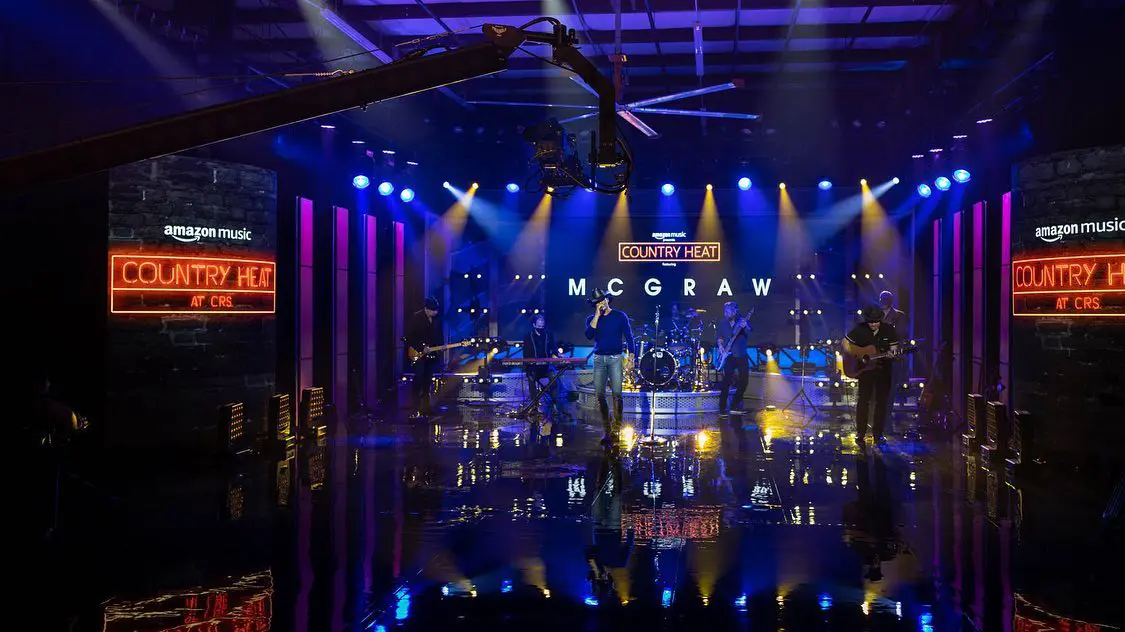Tim McGraw performing live on a brightly lit stage.