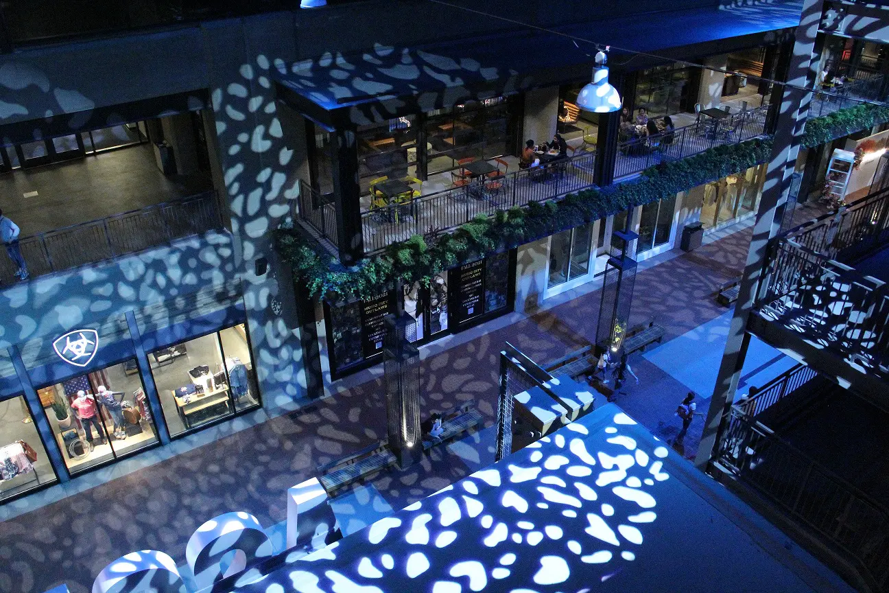 Night scene with decorative lights casting patterns on a street and building.