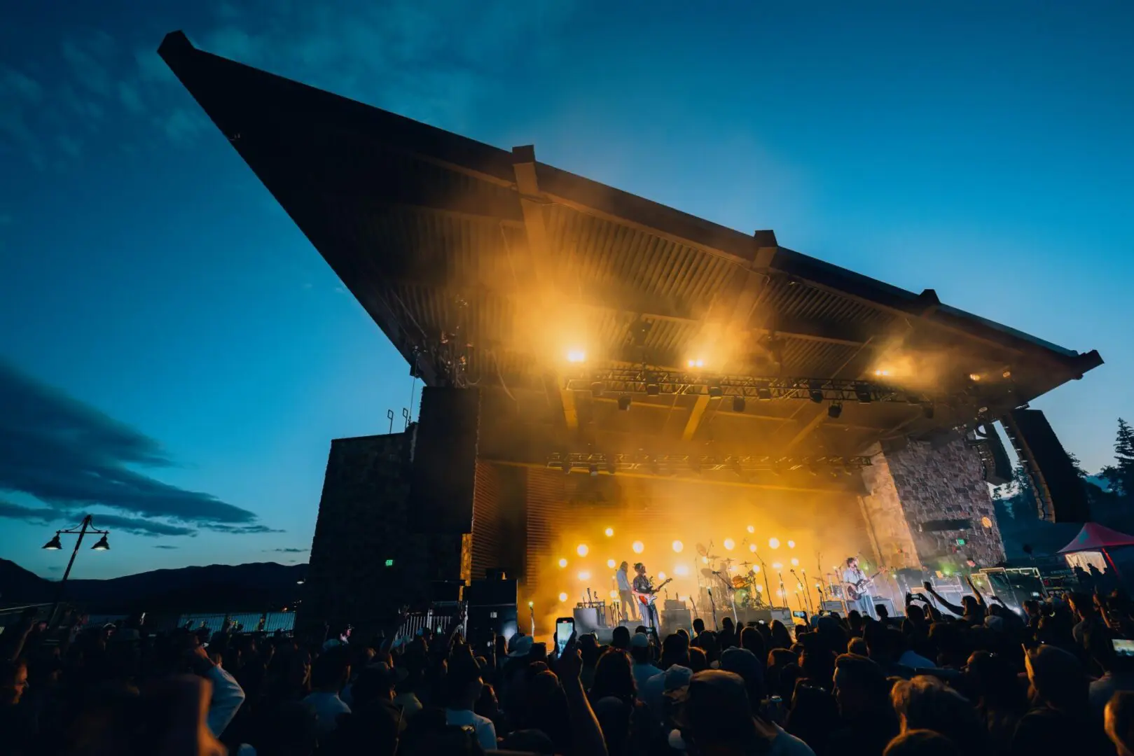 Bandit Lites Provides Concert Lighting for DISPATCH Tour at dusk on a stage in front of a lake.