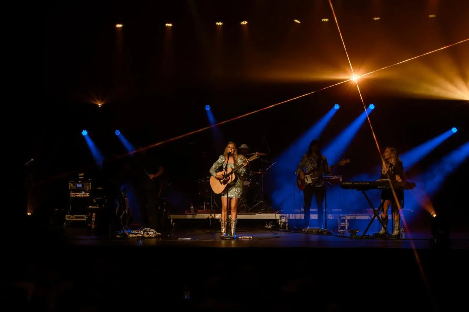 Emily Ann Roberts performs on stage at the Bijou Theater under bright lights for her album release, accompanied by Bandit Lites.