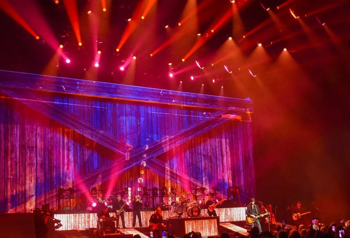 Live concert with vibrant lighting and a band performing on stage.