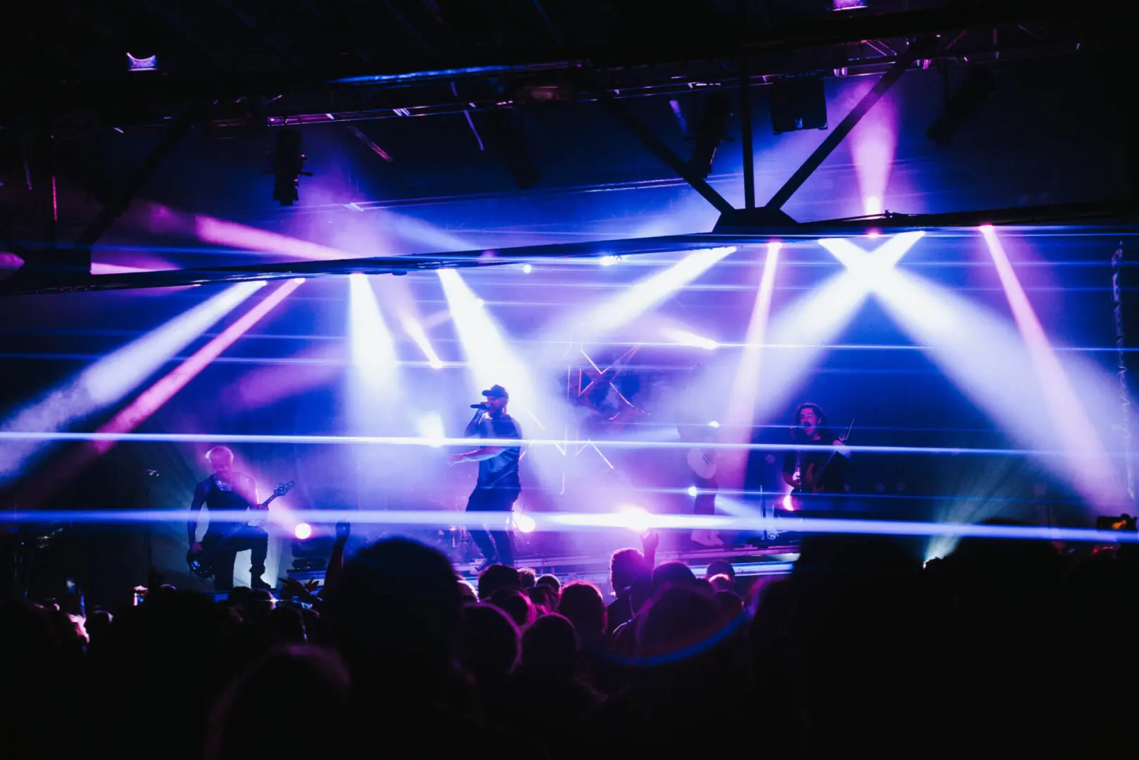 A singer performs on stage with large eye visuals and purple lighting.