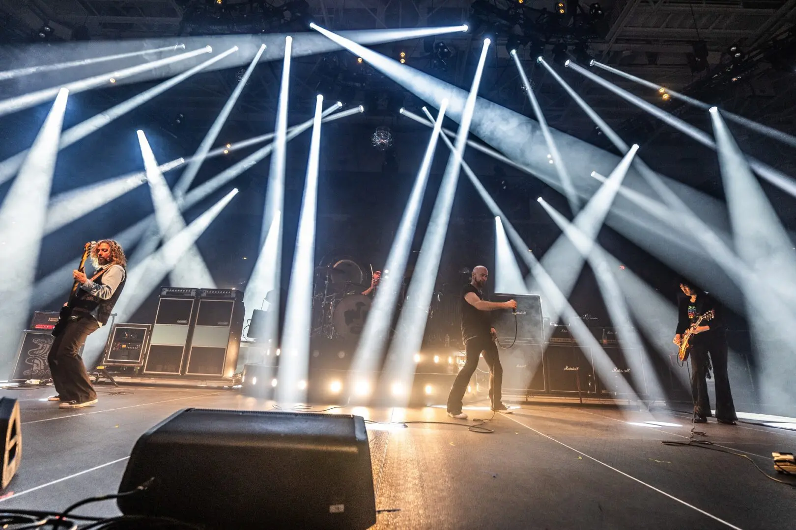 A musician performs on stage with bright white spotlights.