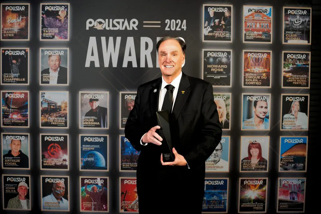 A man in a black suit holding an award at the Polestar 2024 Awards.