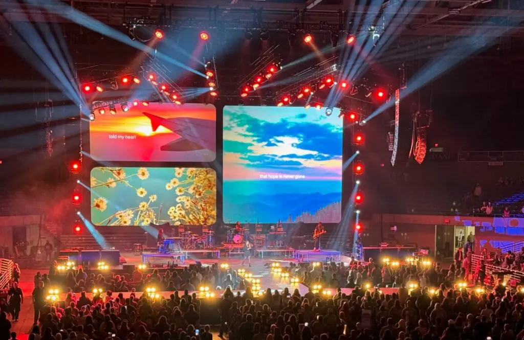 A vibrant concert stage with colorful screens and glowing lights.