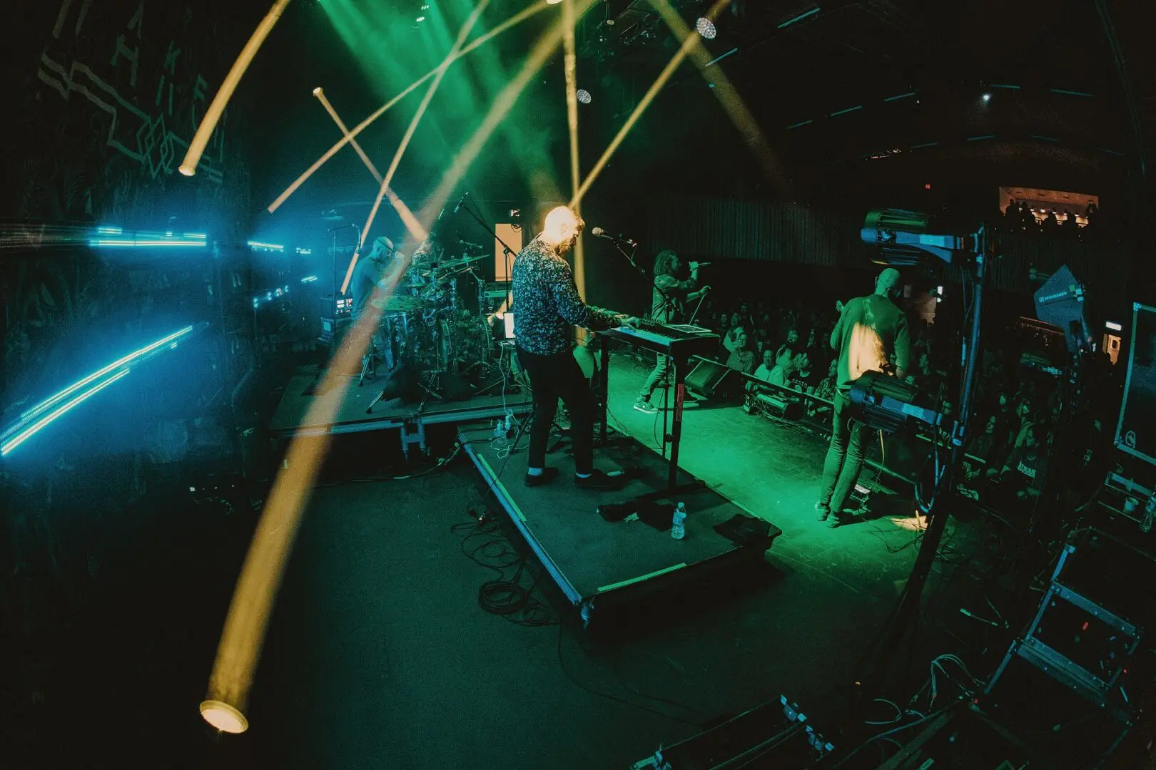 A live band performs on stage with vibrant lighting effects.