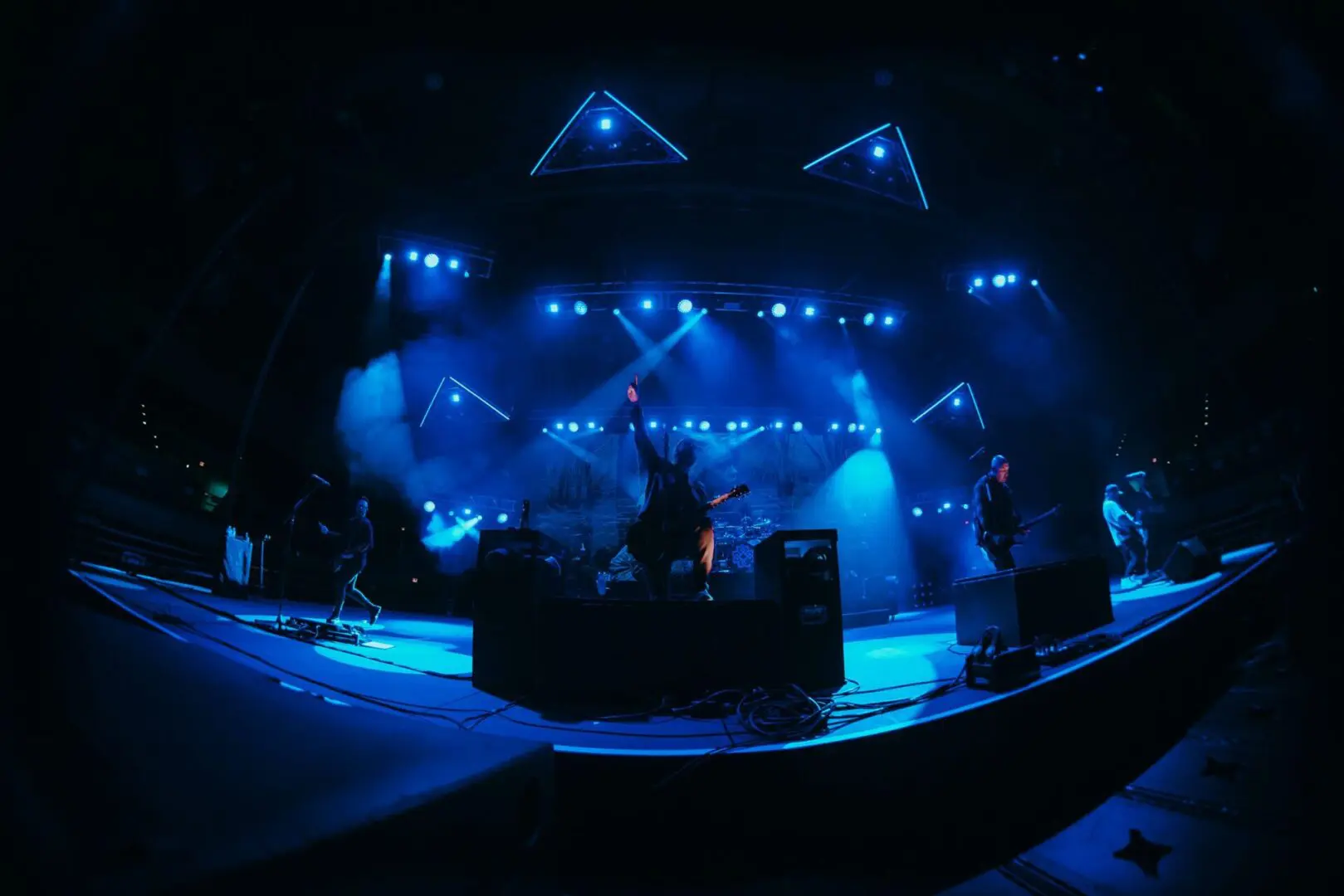 Live concert with vibrant blue stage lighting and energetic performance.