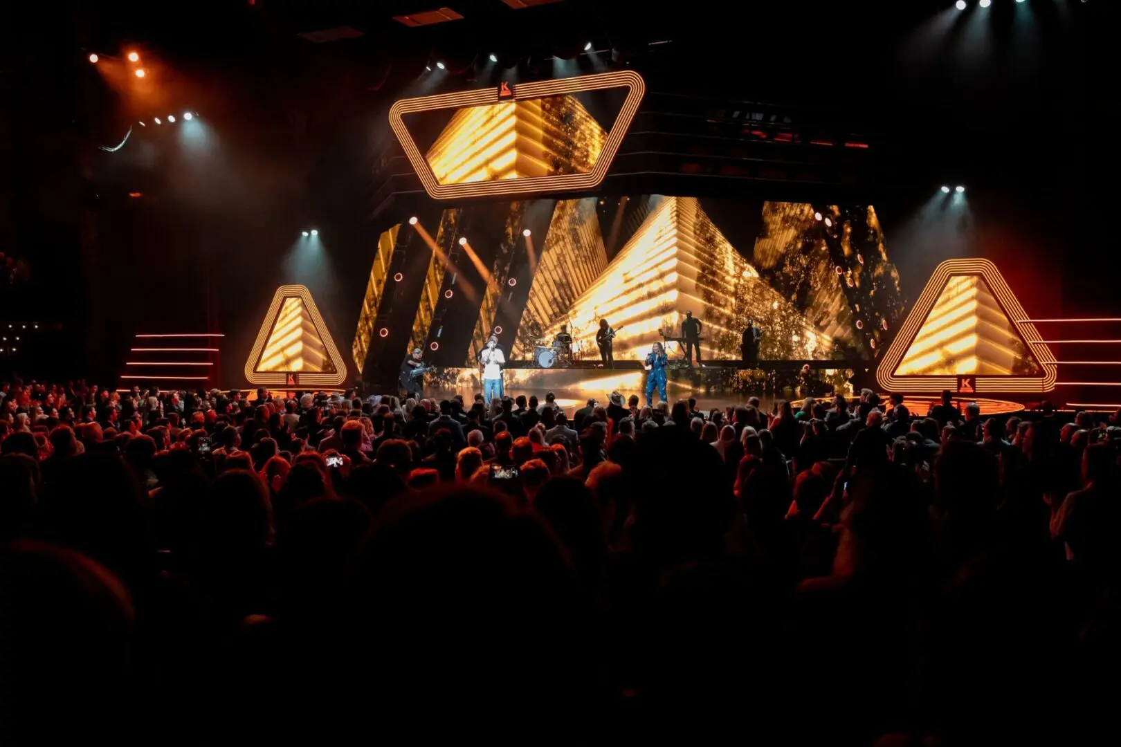 A lively concert with dynamic stage lighting and a large crowd.