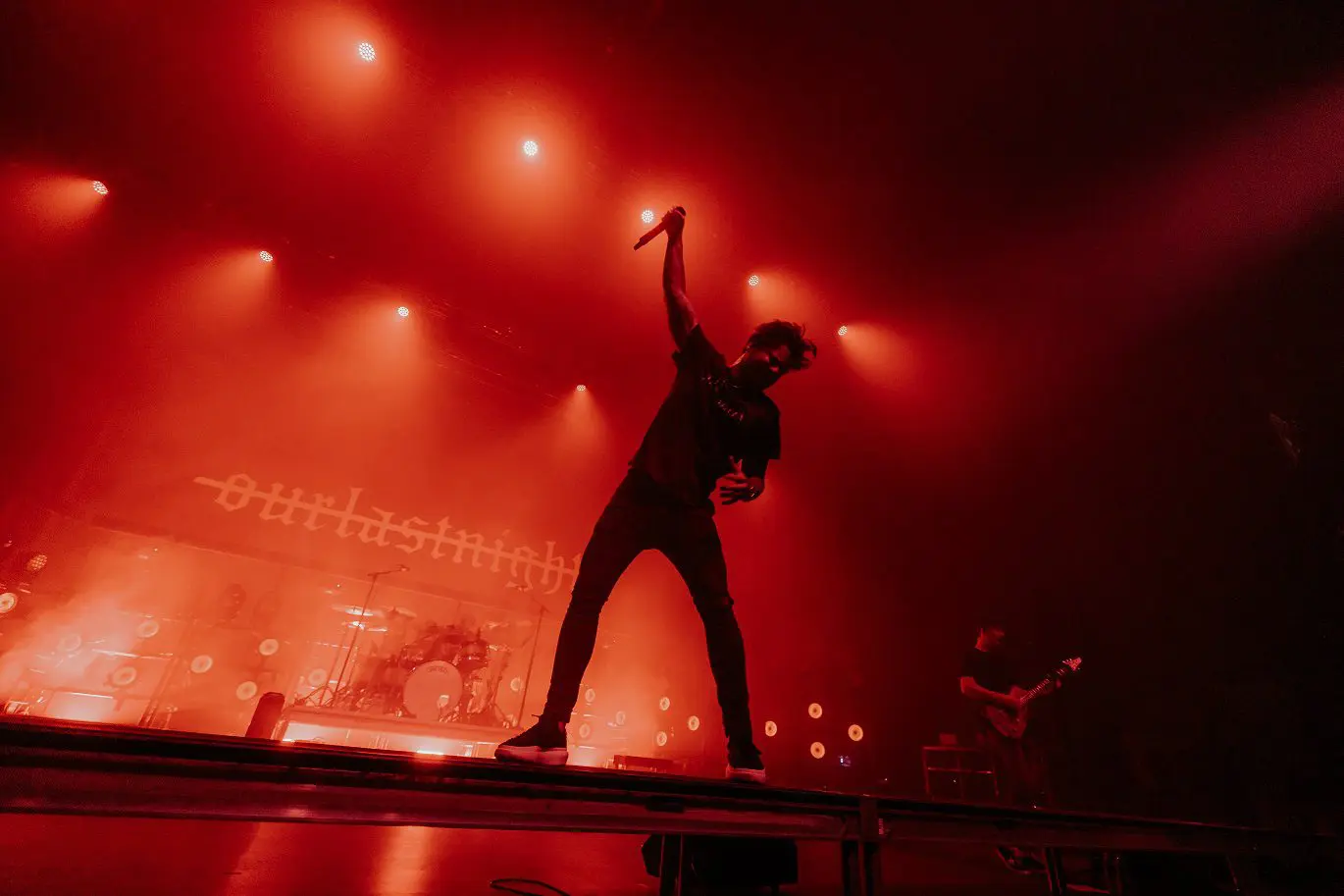 Silhouette of a performer on stage with dramatic red lighting.