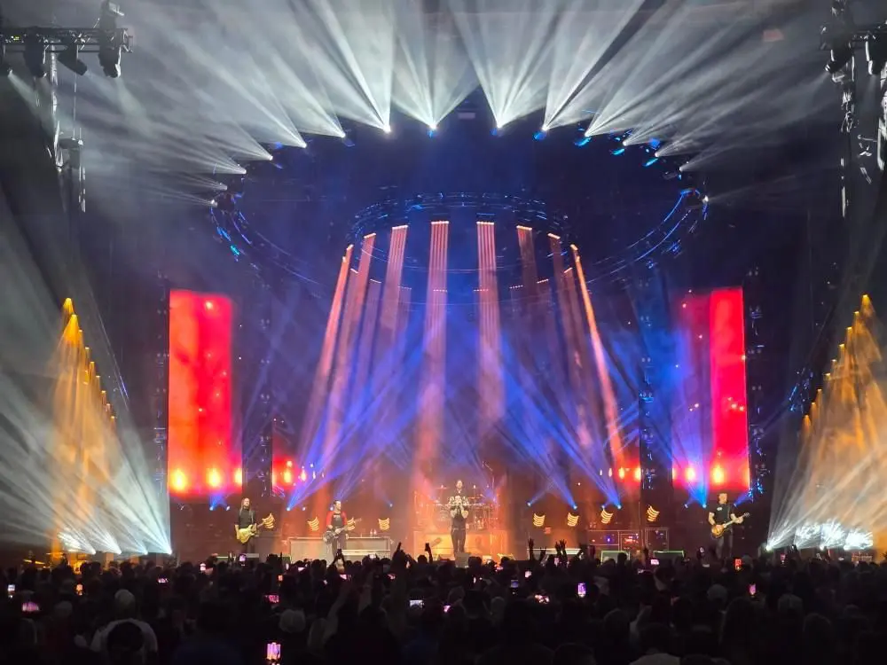A vibrant concert stage with colorful lights and a large crowd.
