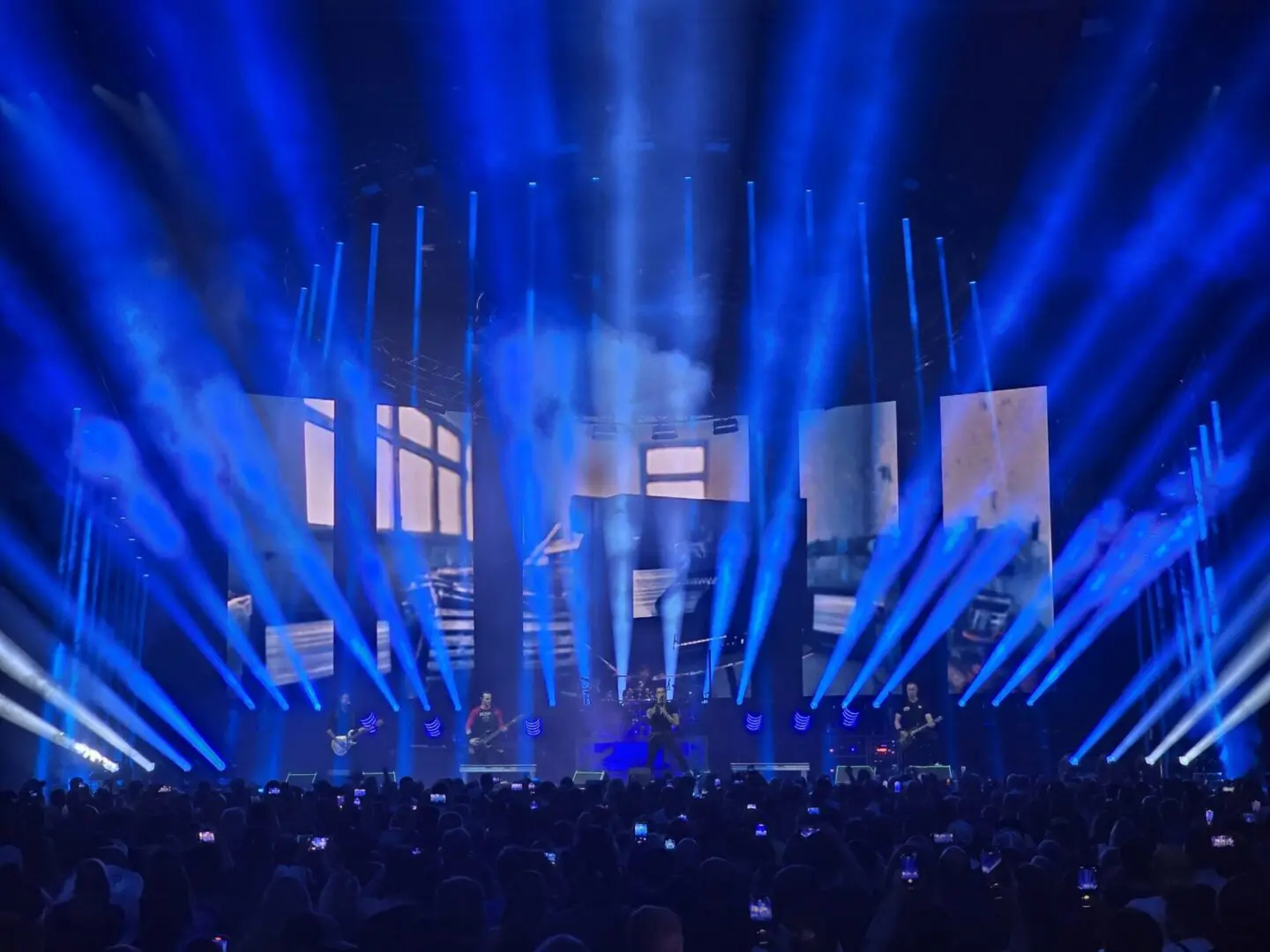 A large concert stage with blue lights and an audience.