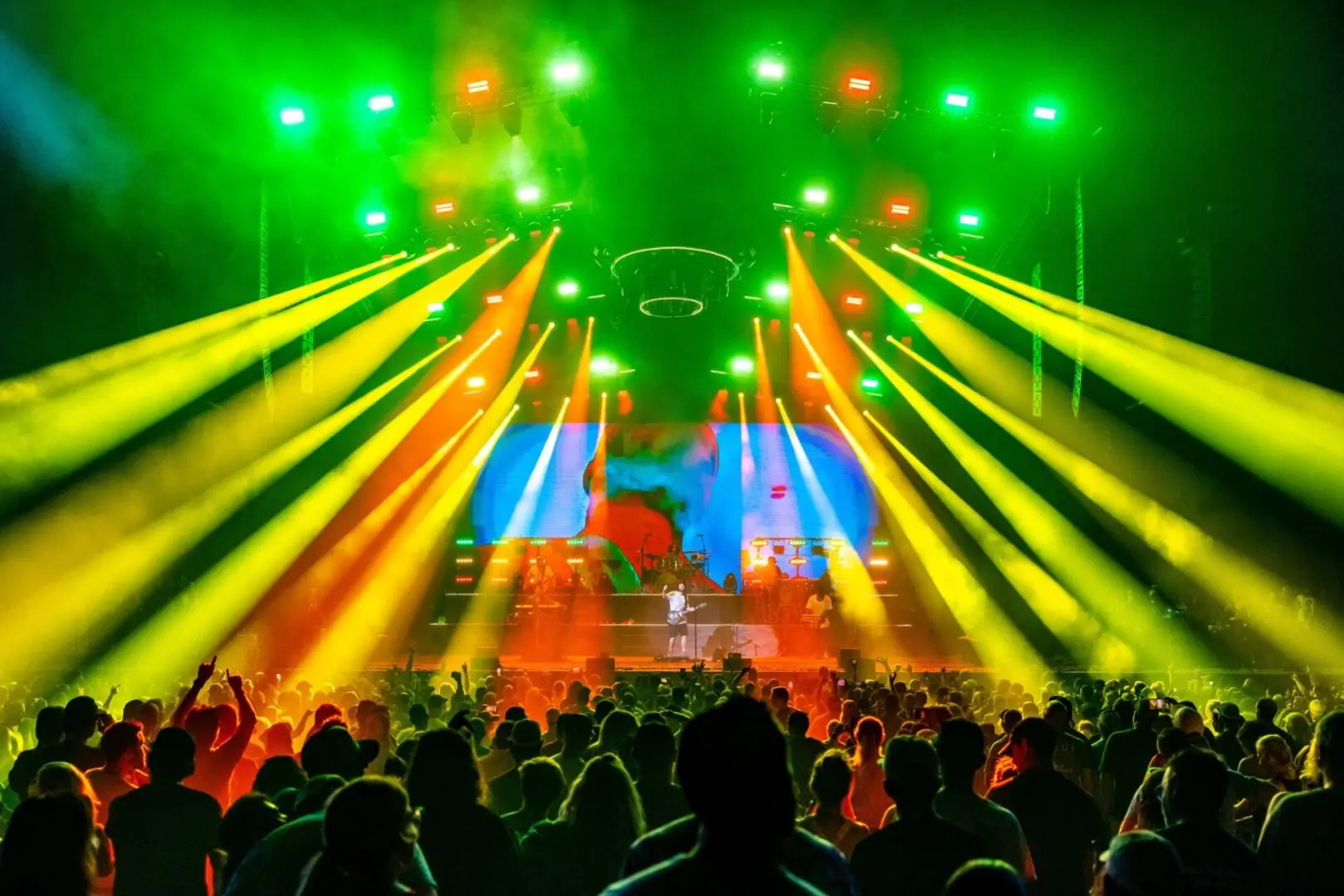 Vibrant concert with colorful lights and enthusiastic crowd.