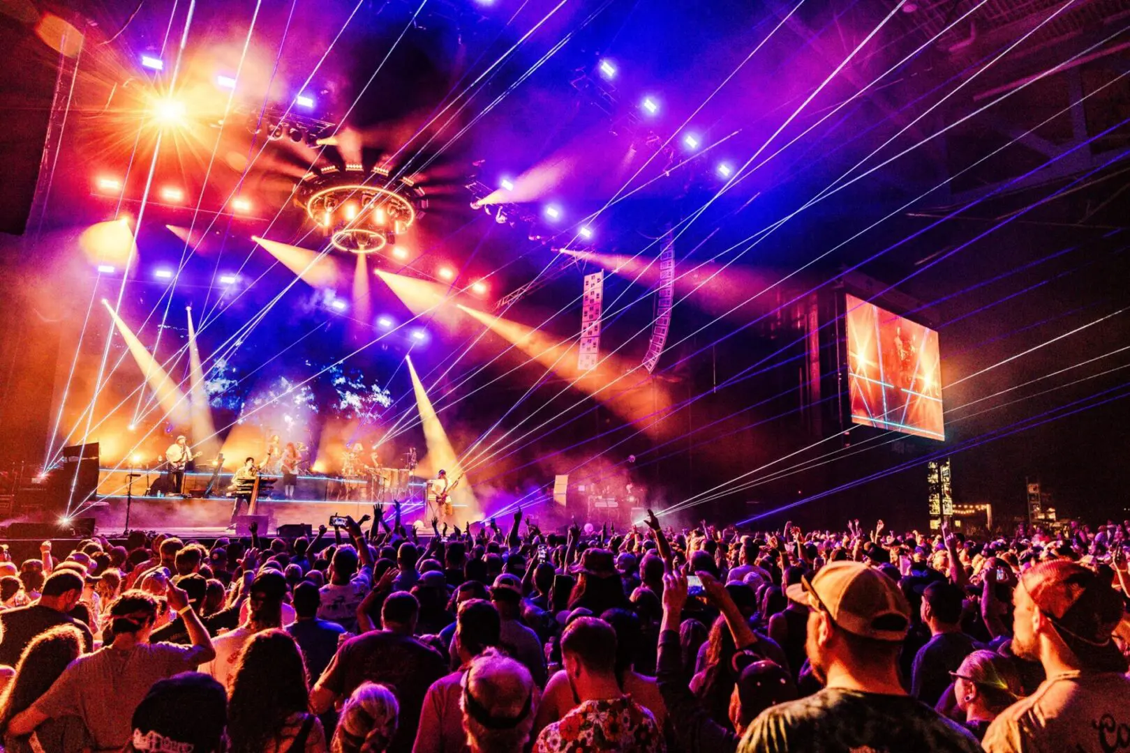 A vibrant music concert with colorful lights and a large crowd.