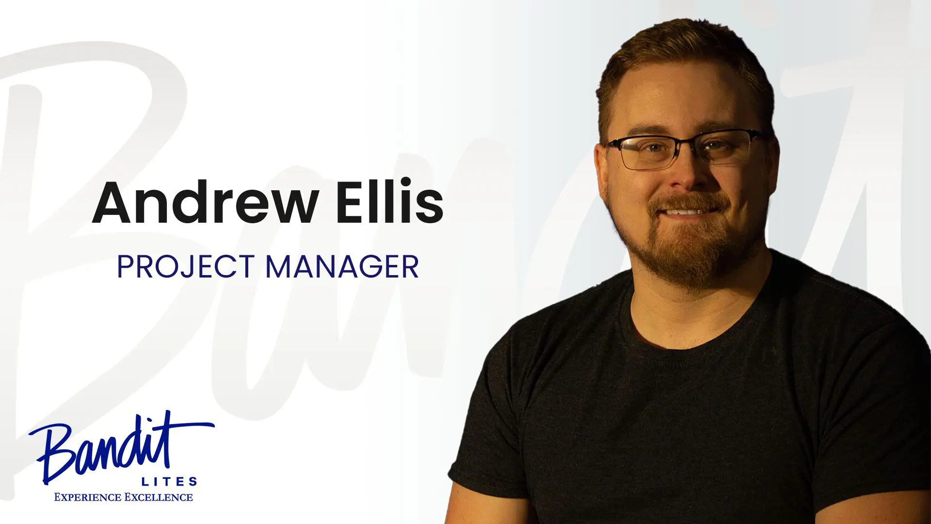 Smiling man with glasses and beard against a dark blue background.