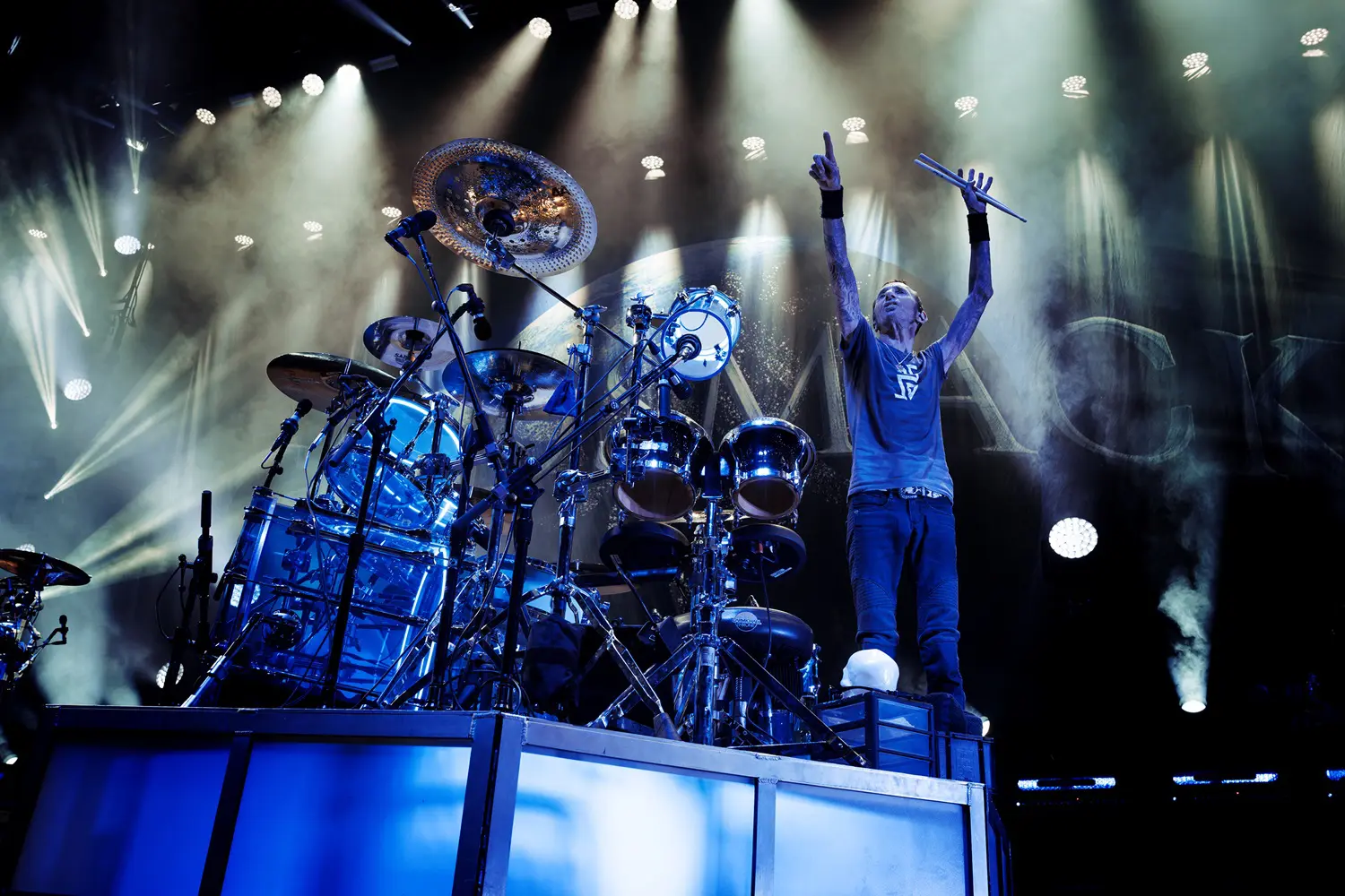 Energetic live rock concert with drummer and lead singer on stage.