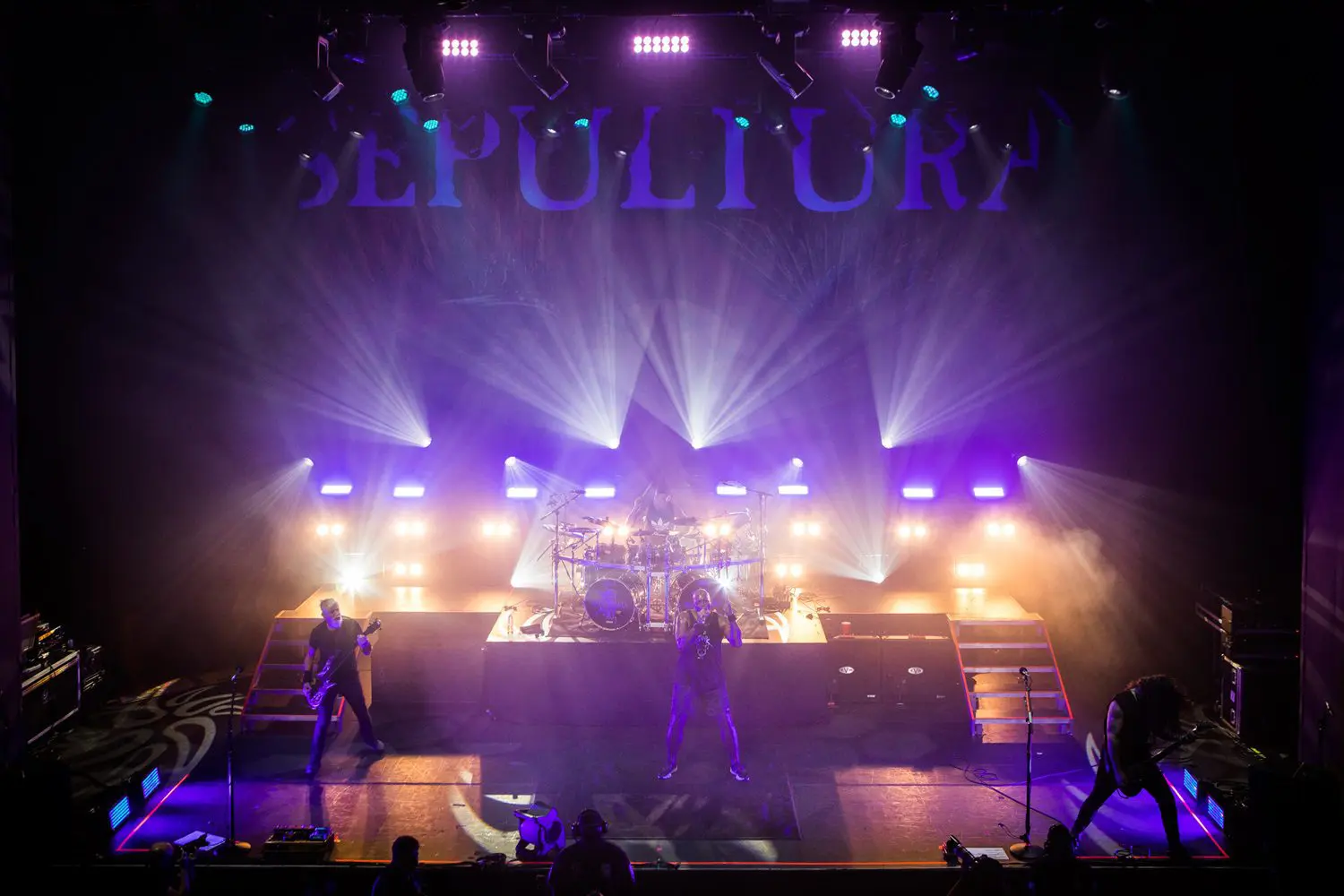 Live band performing on a vibrant stage with dynamic lighting.