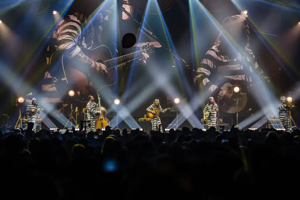 Live concert with vibrant stage lighting and a large audience.