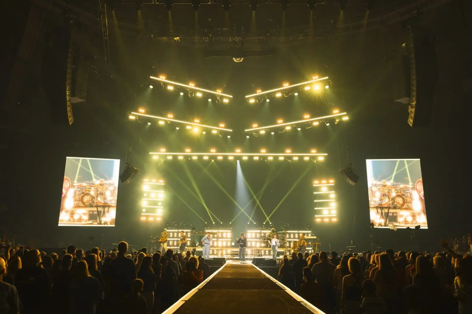 Concert stage with bright lights and large audience.