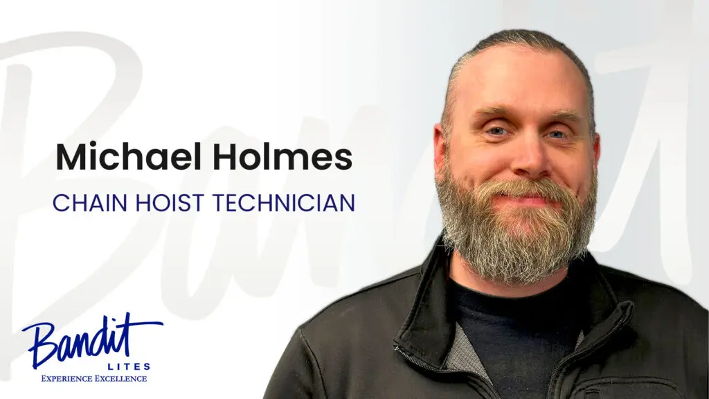 Portrait of a smiling male HVAC technician with a beard and gray hair.