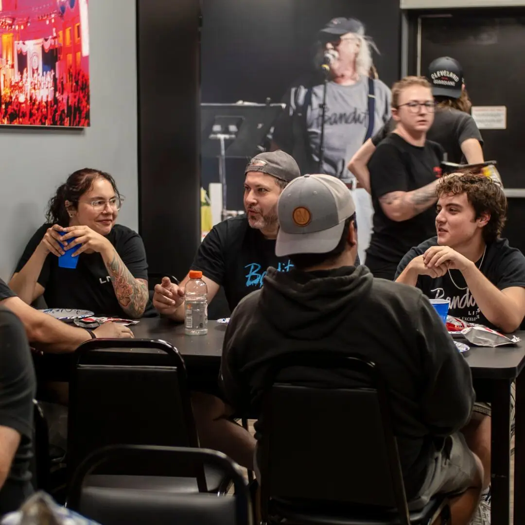 Group of friends enjoying drinks and conversation around a table.
