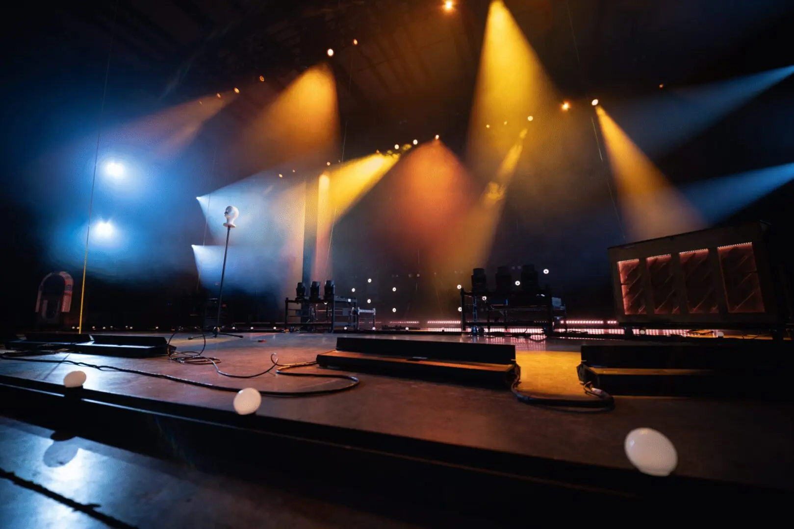 Empty stage lit with warm and cool spotlights, ready for a performance.