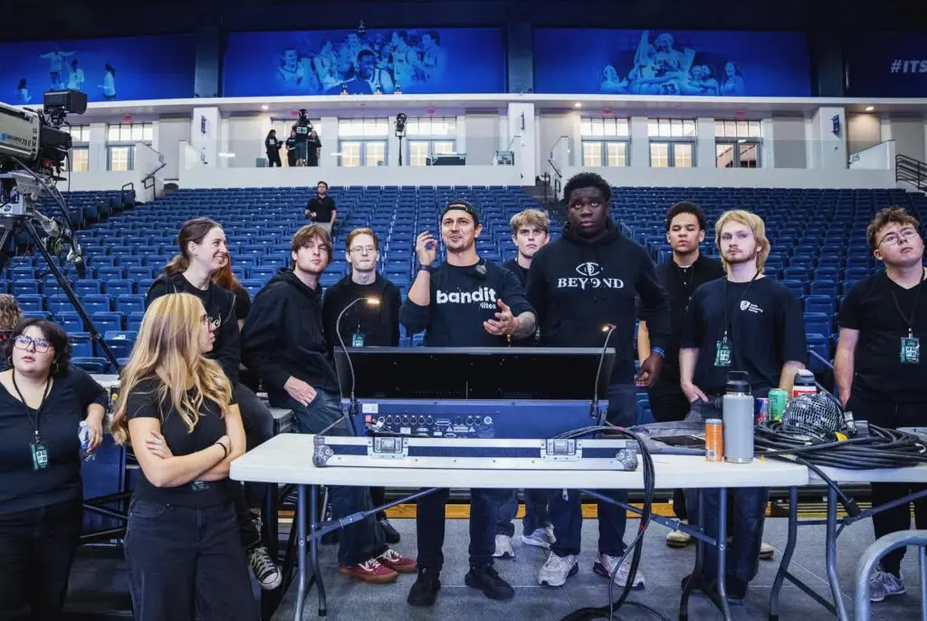 A group of tech enthusiasts gathered around a workstation in a modern lab.