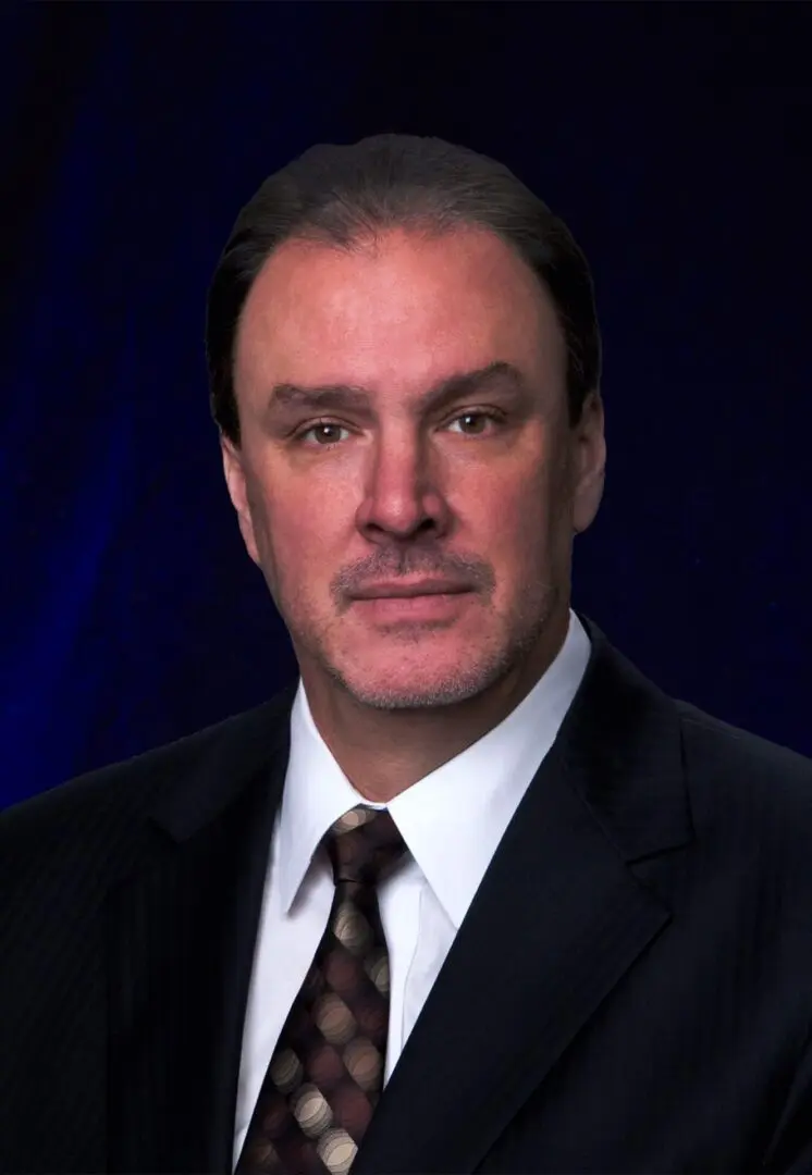 Professional man in a suit against a dark background.