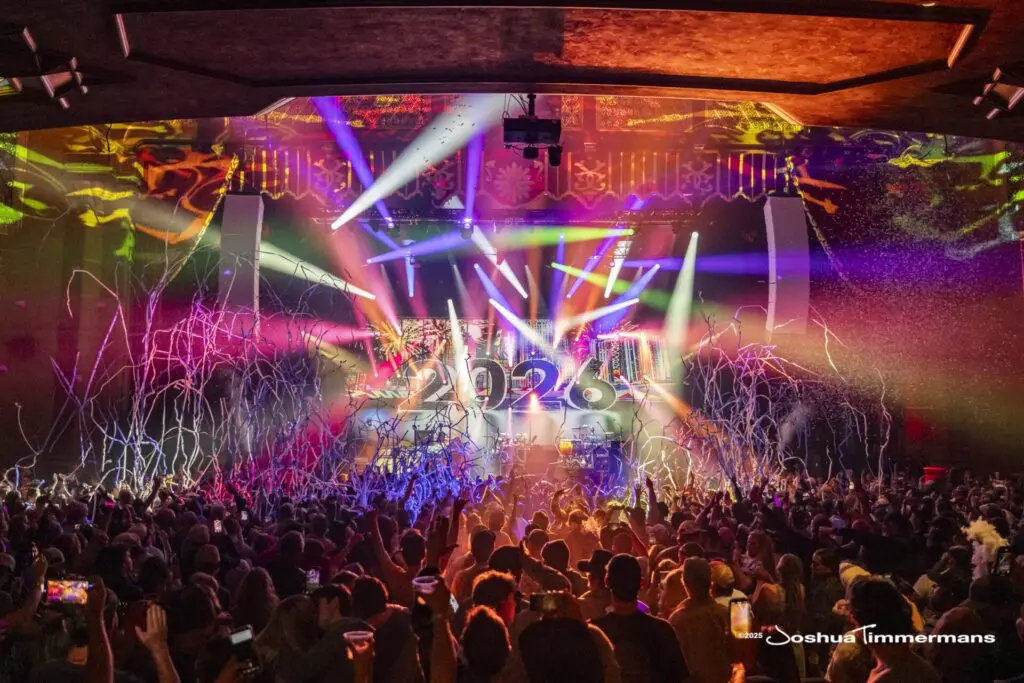 Energetic concert with vibrant lights and a packed crowd.