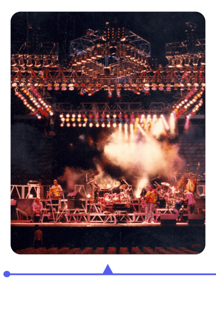 A vibrant live concert with dramatic lighting and smoke effects on stage.
