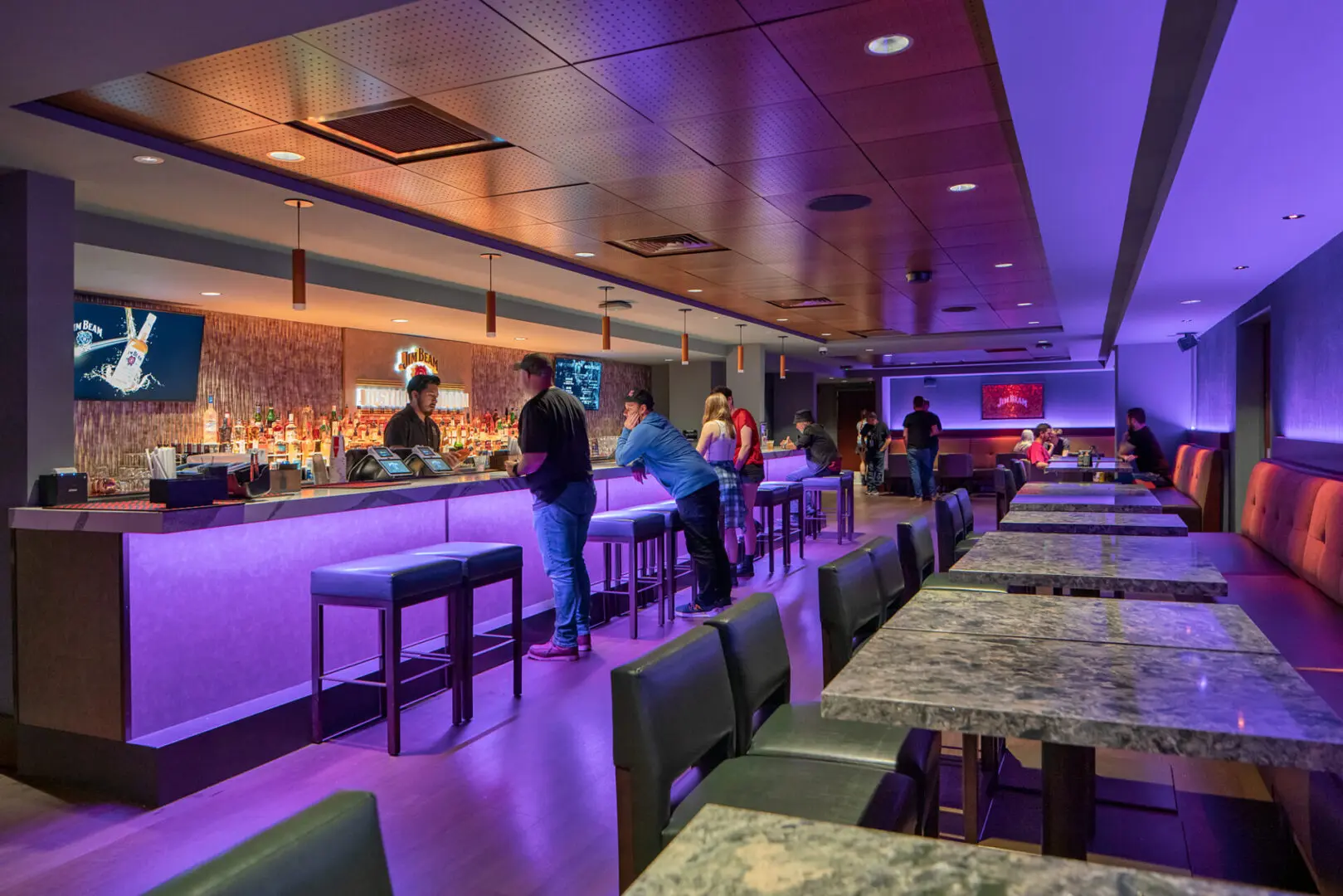 Stylish bar with purple lighting and modern seating.