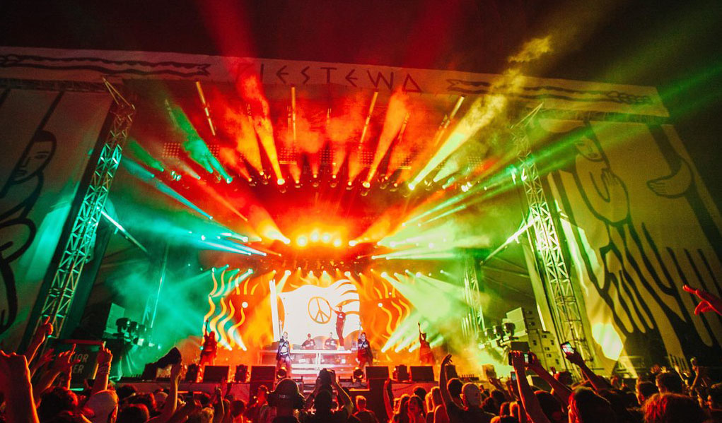 A vibrant concert stage illuminated with colorful lights and enthusiastic crowd.