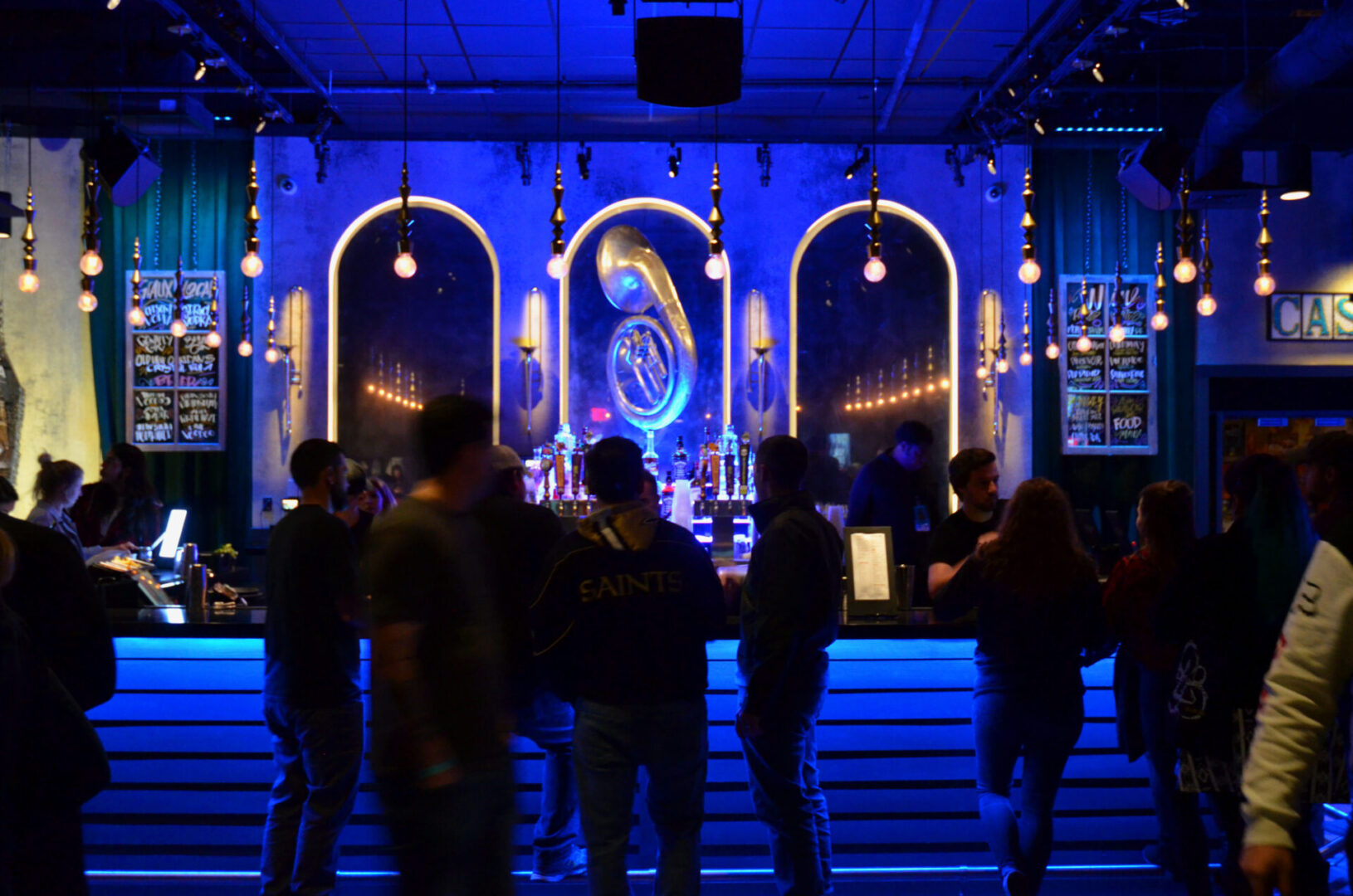 People socializing in a dimly lit nightclub with neon lights.