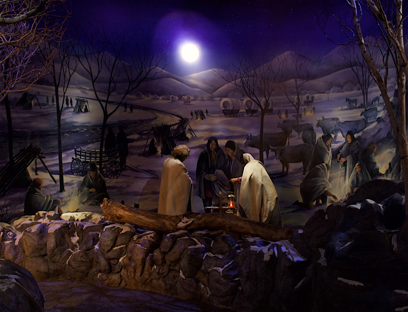 Nativity scene depicting the birth of Jesus under a moonlit night.