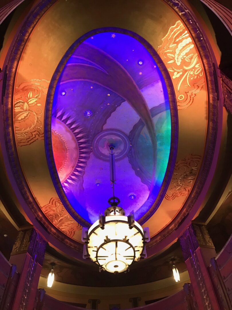 Intricate steampunk clock with colorful illuminated gears.