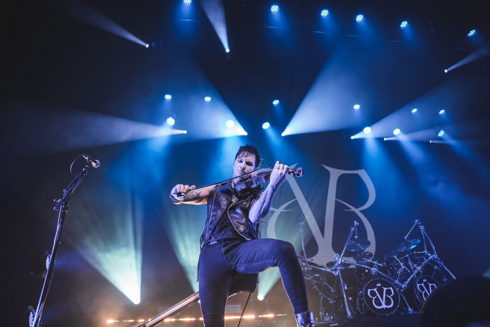 A man playing a violin on stage during the Black Veil Brides Tour.