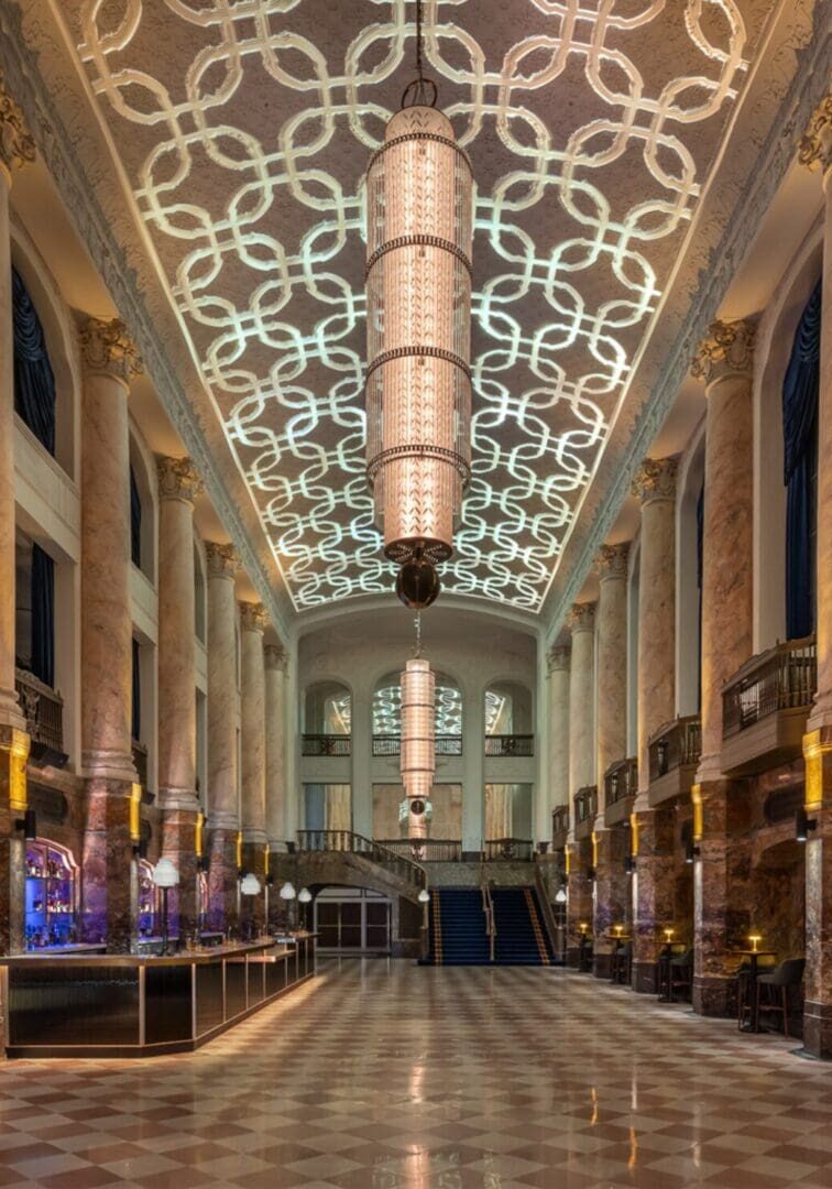 Elegant grand hall with intricate ceiling and polished floor.