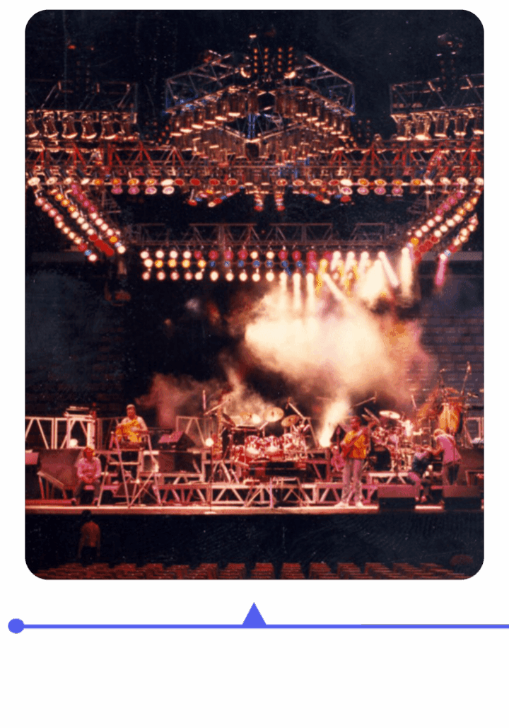 A vibrant live concert with dramatic lighting and smoke effects on stage.